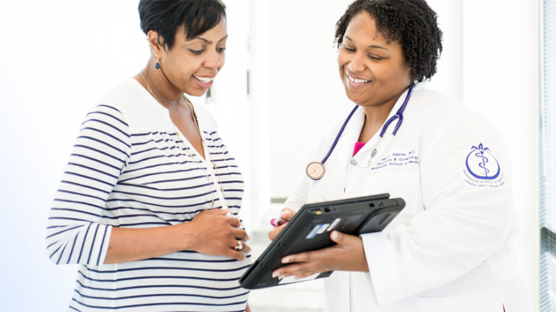 a pregnant woman looks at a doctor's screen